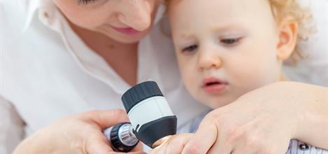 Doctor examining girl's skin.