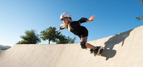 A girl wearing safety gear while skateboarding