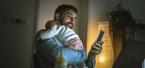 father holds sleeping baby at night