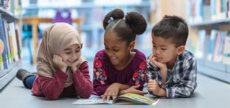 a person and two children reading a book