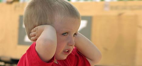 young child covers his ears