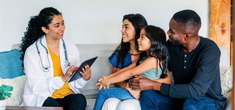a group of people sitting on a couch looking at a tablet